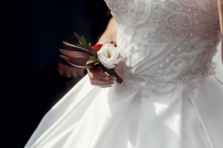bride in wedding dress, holding boutonniere, wedding morning preparation concept. getting ready . space for textの写真素材
