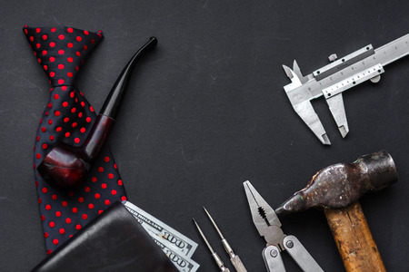 working tools, bow tie leather wallet with money wooden tobacco pipe and razor on black background with space for text, top view. greeting card father day concept flat lay. gentleman setの写真素材