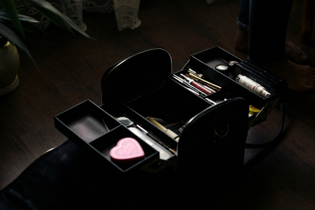 beautician bag full of make up cosmetics. cosmetician case on wooden table, makeup for bride in the morningの写真素材