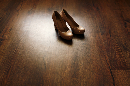 beautiful beige shoes on wooden floor in the morning, bridal morning, wedding preparationの写真素材