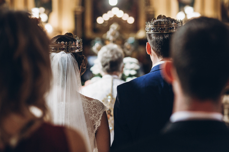 golden crowns on couple bride and groom in church during wedding ceremony, religion traditionsの写真素材