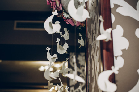 stylish roses decor at wedding reception in restaurant with paper birdsの写真素材