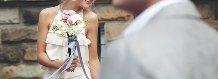 luxury bride in vintage dress  with bouquet and stylish groom posing and smiling in sunny park. happy wedding couple , sensual romantic moment,  long edge.の写真素材