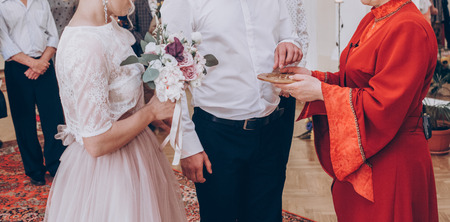 ceremony master gives wedding rings for stylish bride and groom in register office, wedding couple preparing for official wedding ceremonyの写真素材