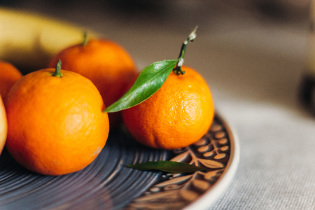 juicy mandarins on blue plate. rustic christmas table with space for text. seasonal holidaysの写真素材