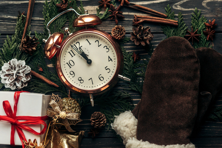 new year midnight concept. stylish vintage clock with almost twelve hour and presents ornaments and branches on christmas rustic wooden background flat lay. 2017 winter holidaysの写真素材