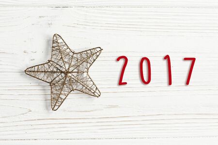 2017 sign text on christmas golden star on stylish white rustic wooden background. space for text....