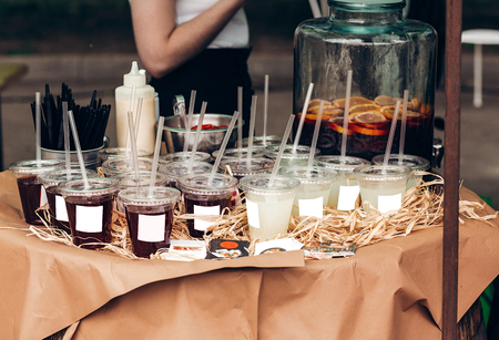 strawberry and lime lemonade, space for text. street food festival. drink bar at reception, catering outdoors. summer picnic. colorful drinks in plastic cups with strawsの写真素材