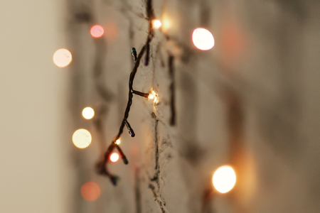 Colorful red and yellow christmas lights hanging on the wall close-up, christmas gift card concept,...