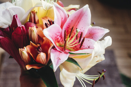 beautiful colorful lily flower bouquet on rustic wooden background. gorgeous bloom lilies on rustic wood backdrop. space for text. greeting card. spring holiday, woman mother dayの写真素材