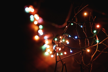 stylish retro christmas garland lights on wood branches, holiday celebration conceptの写真素材