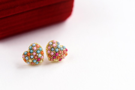 stylish luxury heart earrings with colorful gems on white background, space for text, valentine's...