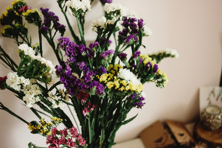 colorful amazing wildflowers in vase on background of rustic roomの写真素材