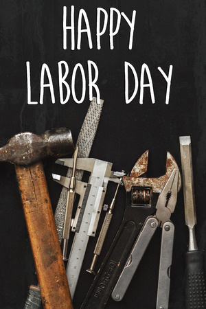 happy labor day text sign. Working tools on black background top view. instruments set for hand work and repairing. Renovation concept flat lay, copy space.の写真素材