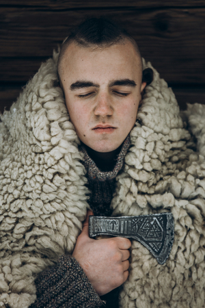 Viking portrait, strong handsome viking warrior with steel axe ritual before battle, thor cosplay, scandinavian historical costume clothes, ancient warrior with mohawk face close-upの写真素材