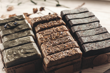 natural soap. handmade herbal soap with wildflowers, healing flowers, mint, dried lavender, top view. eco natural product for skin care. soap on white rustic background with dried herbsの写真素材