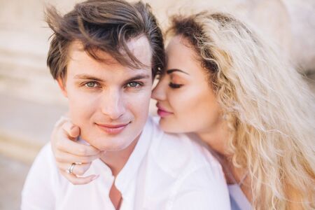 Newlywed couple portrait, hipster couple on honeymoon face closeup, beautiful blonde woman hugging handsome man in white shirtの写真素材