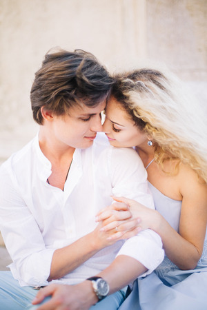 Newlywed couple portrait, hipster couple on honeymoon face closeup, beautiful blonde woman hugging handsome man in white shirtの写真素材