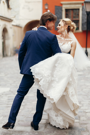 Newlywed couple dancing in the street, happy emotional bride dancing outdoors with elegant groom, dancers couple posing in the cityの写真素材