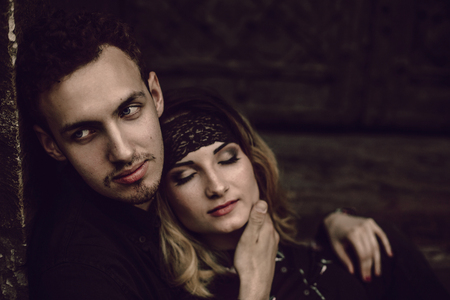 stylish gypsy couple in love embracing in evening city street at old building. woman and man hugging, romantic french atmospheric moment. love mood. modern bride and groomの写真素材