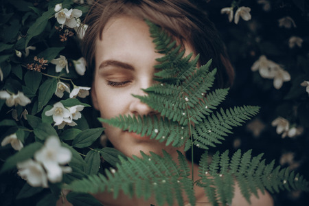 stylish hipster woman with fern leaf embracing. girl portrait with natural herb, boho sensual bride. romantic moment. rustic eco wedding concept. beautiful woman relaxingの写真素材