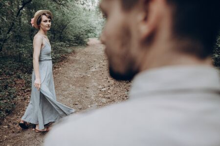 stylish hipster couple walking and dancing in green summer forest. happy man and woman in love,...
