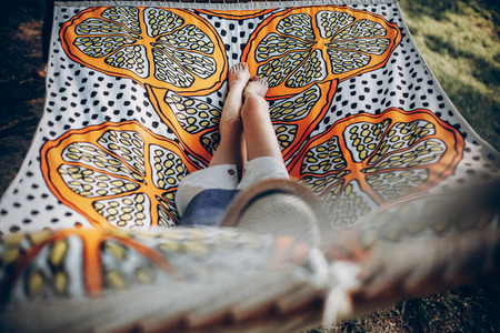 stylish hipster woman legs on hammock in sunny summer park. blonde girl resting in forest, smiling and enjoying day. summer vacation, space for text. campingの写真素材