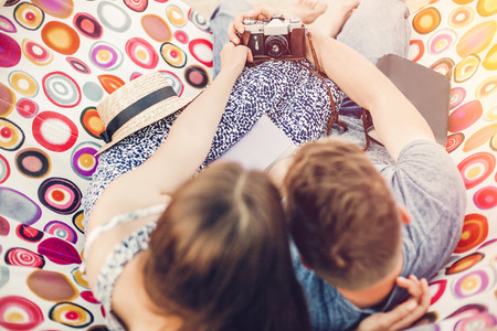 happy hipster couple making selfie with photo camera and relaxing in hammock in sunset light on the beach, summer vacation. stylish man and beautiful woman taking self portrait. space for textの写真素材
