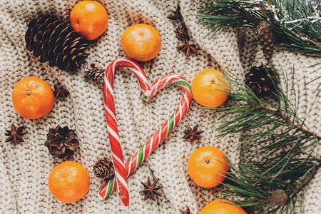 christmas candy and cozy sweater with anise and tangerine on rustic background top view, space for text. xmas seasonal greetings card flat lay. winter holidays moodの写真素材