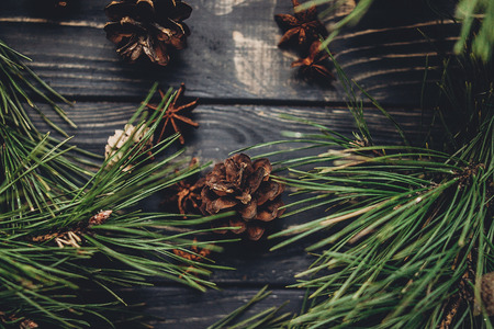 christmas tree branches with pine cones and anise on rustic background top view, space for text. stylish xmas seasonal greetings image. winter holidays mood. atmospheric still lifeの写真素材