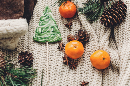 christmas tree candy and cozy sweater with anise and gloves and tangerine on rustic background top view, space for text. xmas seasonal greetings card. winter holidays moodの写真素材