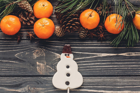 christmas image flat lay. christmas candy snowman and fir branches with tangerine and anise  on...