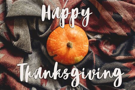 happy thanksgiving text sign on autumn pumpkin on stylish scarf fabric flat lay, space for text.  seasonal greetings, fall holidays. harvest time. cozy moodの写真素材