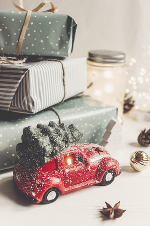 modern christmas ornaments and car toy with tree, presents cones anise on white wooden background. merry christmas concept. seasonal greetings. happy holidays, xmas card, hyggeの写真素材