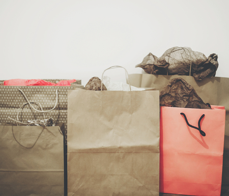 shopping, christmas shopping concept, space for text. big sale. many brown paper bags with presents on background of white wall. black friday, seasonal saleの写真素材