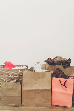 many brown paper bags with presents on background of white wall.の写真素材