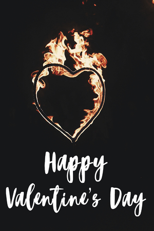 happy valentine's day text, greeting card. fire heart firework on black background, fire show in night. happy valentines day concept. bengal fire burning heart. space for text. vertical imageの写真素材