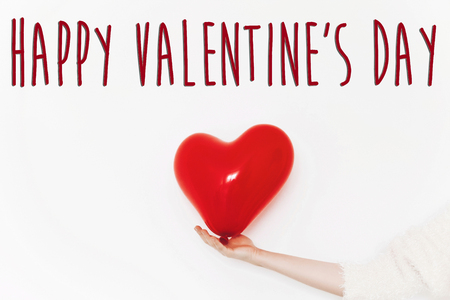 happy valentine's day text sign. happy valentines concept. red heart balloon in hands on white background with space for text. greeting cardの写真素材