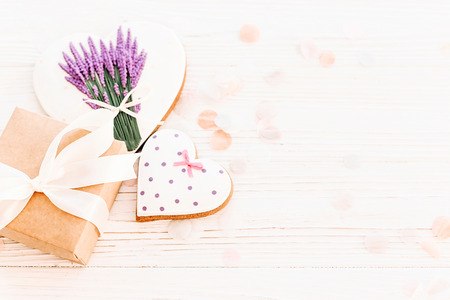 cookie heart with lavender flowers and craft gift box on white rustic wood background  flat lay. space for text. happy valentine's day or women's. happy mother's day greeting card.の写真素材