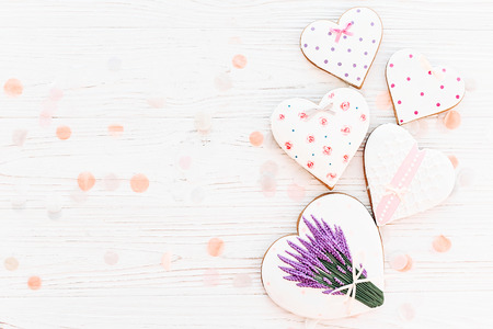 cookie hearts with lavender flowers on white rustic wooden background with confetti flat lay. space for text. happy mother's day greeting card.  happy valentine's day or women'sの写真素材