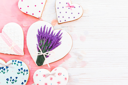 happy mother's day greeting card. cookie heart with lavender flowers on white rustic wooden background with confetti flat lay. space for text. happy valentine's day or women'sの写真素材