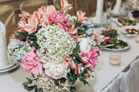 beautiful decorated centerpiece table with hydrangea bouquets in vases and greenery at luxury wedding reception in restaurant. stylish decor and adorningの写真素材