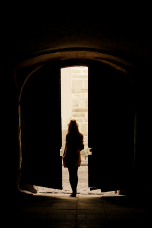 silhouette of young  woman hipster walking in the street of an old European townの写真素材