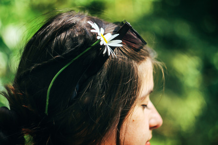 beautiful flower in woman braids, enjoying travel in summer woodsの写真素材