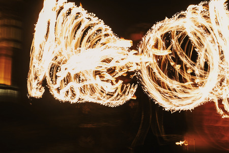 amazing fire show at night at festival or wedding party. Fire dancers swing, spinning fire and man...