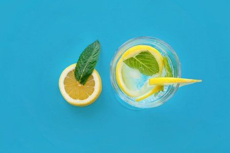 mojito cocktail drink with lemon slice and mint flat lay on trendy blue paper background. space for text. summer vacation and party concept. summer holidaysの写真素材