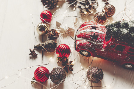 modern christmas ornaments, car toy with tree, and cones anise on white wooden background top view. merry christmas concept. seasonal greetings. happy holidays, xmas cardの写真素材