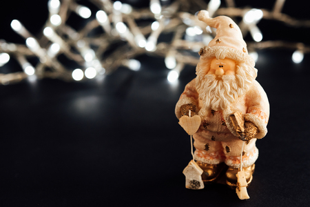 amazing beautiful  christmas silver vintage garland lights and santa toy on stylish black backgroundの写真素材