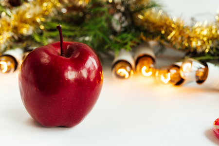 green branches of cedar or fir and amazing beautiful christmas golden vintage garland lights  and apple on white backgroundの写真素材
