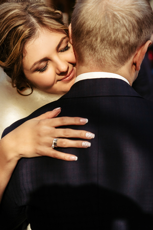 happy gorgeous blonde bride and stylish handsome groom hugging with true emotions on background of old city wallの写真素材